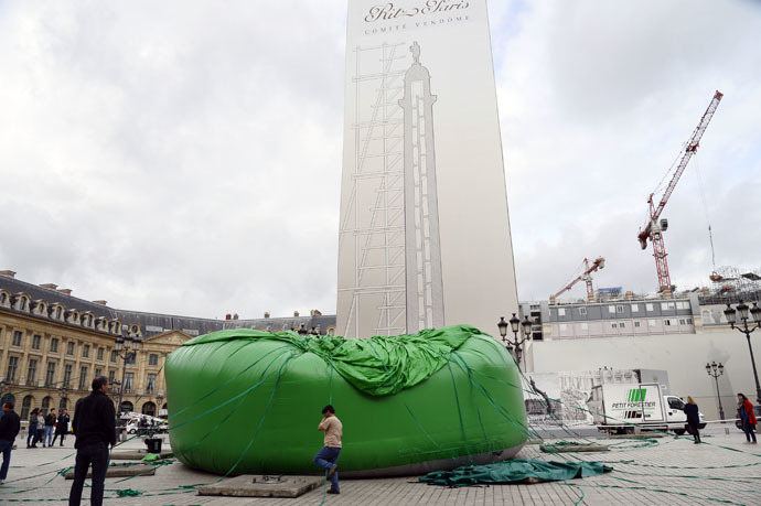 A picture taken on October 15, 2014 shows workers setting up a 24-meter-high inflatable sculpture, called "Tree", by US artist Paul McCarthy on the Place Vendome in Paris. (AFP Photo / Bertrand Guay)