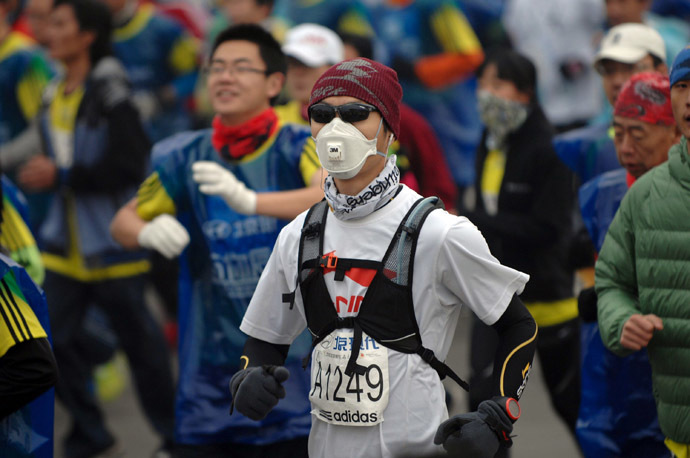 A runner wears a mask as he takes part in the 34th Beijing International Marathon which began at Tiananmen Square in Beijing on October 19, 2014. (AFP Photo/China Out)