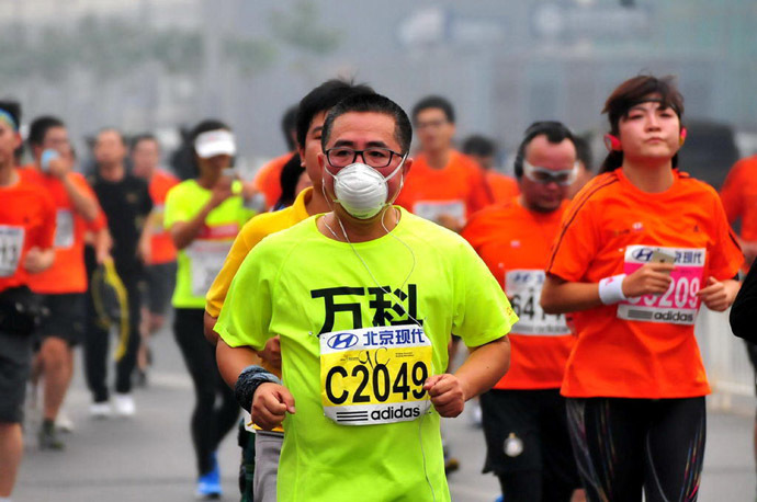 A runner wears a mask as he takes part in the 34th Beijing International Marathon which began at Tiananmen Square in Beijing on October 19, 2014. (AFP Photo/China Out)