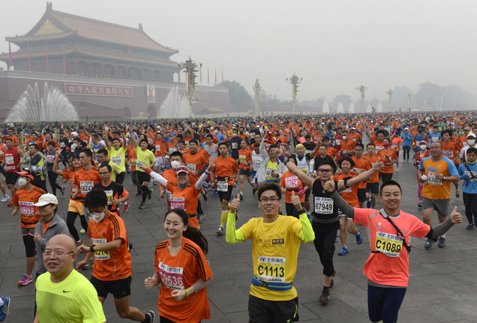 Participants run past the Tiananmen gate with a portrait of China's late leader Mao Zedong on a hazy day during the Beijing International Marathon in Beijing October 19, 2014. (Reuters/Stringer)