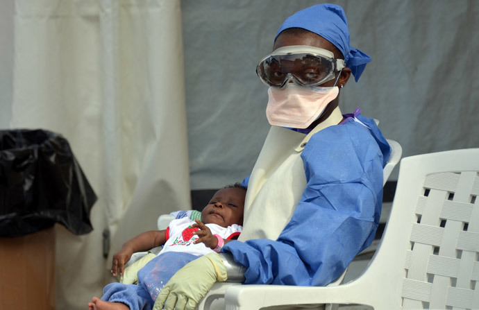 A Liberian health worker holds a baby infected with the Ebola virus at the NGO Medecins Sans Frontieres (Doctors Without Borders) Ebola treatment center in Monrovia. (AFP Photo / Zoom Dosso)