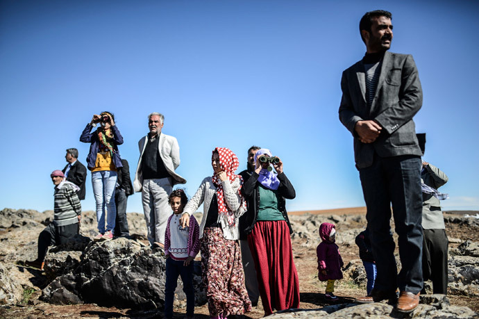 Members of the Syrian Kurdish Altay family try to spot on October 20, 2014 from the Turkish Syrian border village of Mursitpinar, their relative, Zamani Suruc, who is fighting Islamic State (IS) jihadists in the Syrian border town of Kobane, also known as Ain al-Arab. (AFP Photo / Bulent Kilic)