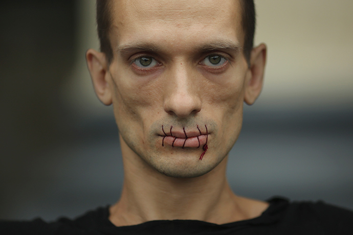 Artist Pyotr Pavlensky, a supporter of jailed members of female punk band "Pussy Riot", looks on with his mouth sewed up as he protests outside the Kazan Cathedral in St. Petersburg (REUTERS / Trend Photo Agency / Handout)