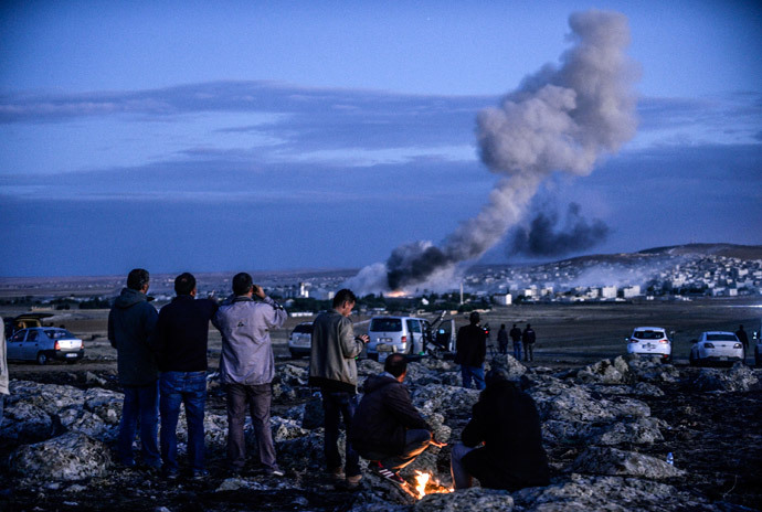 Kurdish people observe smoke rising from the Syrian town of Kobani on October 20, 2014. (AFP Photo / Bulent Kilic)