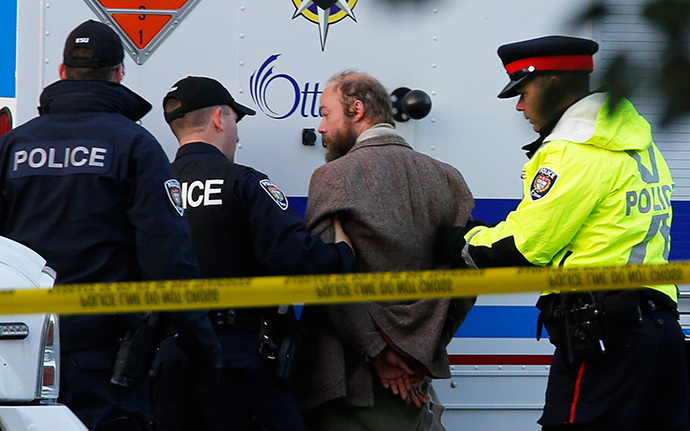 Officers search a man who approached police tape near the Canada War Memorial as PM Harper paid respects to Cpl. Nathan Cirillo, October 23, 2014. (Reuters / Chris Wattie)