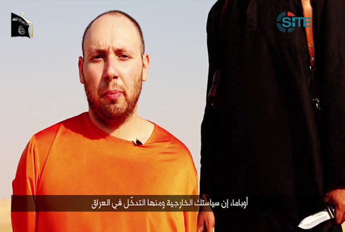 An image grab taken from a video released by the Islamic State (IS) and identified by private terrorism monitor SITE Intelligence Group on September 2, 2014, purportedly shows 31-year-old US freelance writer Steven Sotloff dressed in orange and on his knees in a desert landscape speaking to the camera before being beheaded by a masked militant (R). (AFP Photo / Site Iintelligence Group / HO)