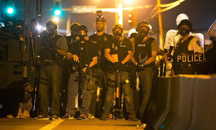 Police officers keep watch while demonstrators (not pictured) protest the death of black teenager Michael Brown in Ferguson, Missouri August 12, 2014 (Reuters / Mario Anzuoni)