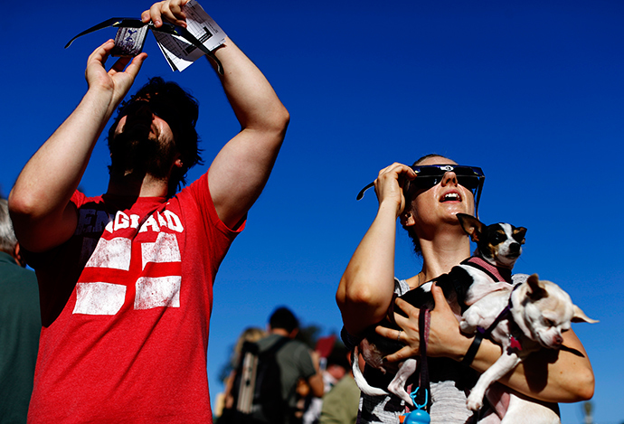 Angie Henderson holds her Chihuahua dogs as she looks up to view a partial solar eclipse outside the Reuben H. Fleet Science Center in San Diego, California October 23, 2014 (Reuters / Mike Blake)