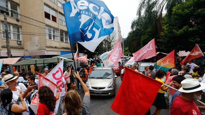 Supporters of Brazil's presidential candidates Aecio Neves (Blue) of Brazilian Social Democratic Party (PSDB) and Dilma Rousseff (red) of Workers Party (PT) cheer ahead of Sunday's election runoff at a weekly street market in Rio de Janeiro October 25, 2014.(Reuters / Ricardo Moraes )