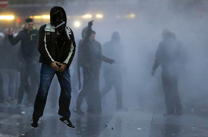 Protesters gesture towards police using a water cannon against them during a demonstration organized by German far-right groups in Cologne October 26, 2014. (Reuters/Wolfgang Rattay)