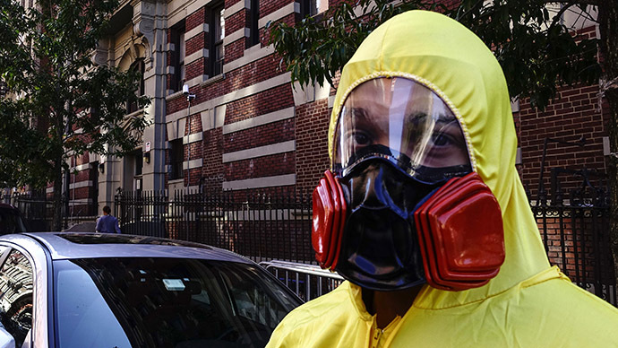 A man wearing personal protective equipment (PPE) as a Halloween costume, stands in front of the building where Dr. Craig Spencer lives in New York October 25, 2014. (Reuters/Eduardo Munoz)