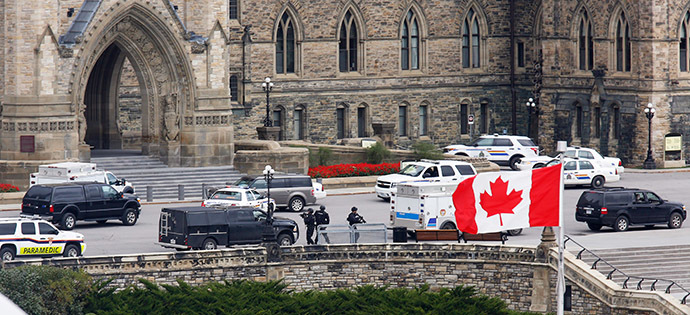 Armed RCMP officers approach Centre Block on Parliament Hilll following a shooting incident in Ottawa October 22, 2014. (Reuters/Chris Wattie)