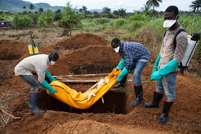 Volunteers in protective suit burry the body of a person who died from Ebola in Waterloo, some 30 kilometers southeast of Freetown (AFP Photo / Florian Plaucheur)