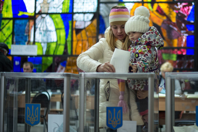 A woman puts a ballot into a ballot box at a polling station in Kiev during the Ukrainian early parliamentary election. (RIA Novosti/Ramil Sitdikov)