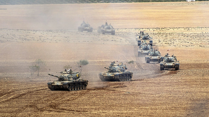 Turkish Army tanks take position as they turn towards the Syrian city of Kobani on September 29, 2014 in Suruc after three mortars hit the Turkish side. (AFP Photo/Bulent Kilic)