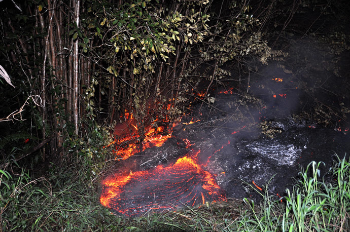 This October 28, 2014 image provided by the US Geological Survey(USGS) shows the lava flow eminating from the KÄ«lauea volcano in Hawaii moving through thick vegetation near the Pahoa cemetery. (AFP Photo)