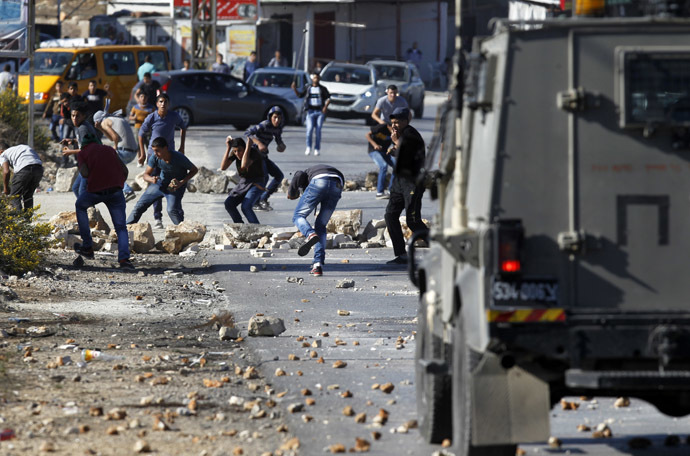 Palestinian youths from the Jalazoun refugee camp clash with Israeli security forces on a road at the entrance of the Jewish West Bank settlement of Beit El, north of Ramallah, following a march by Palestinian demonstrators against Israeli restrictions on the Al-Aqsa mosque and against Jewish settlements in the West Bank on October 24, 2014 (AFP Photo)