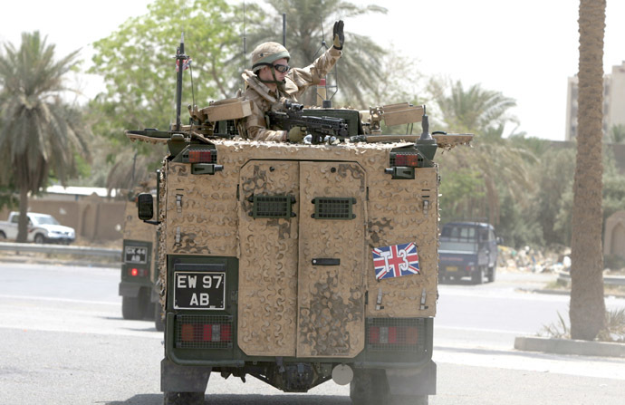 A British soldier waves as he rides in a military vehicle along the parade ground in Baghdad's fortified "Green Zone" on May 16, 2009. (AFP Photo)
