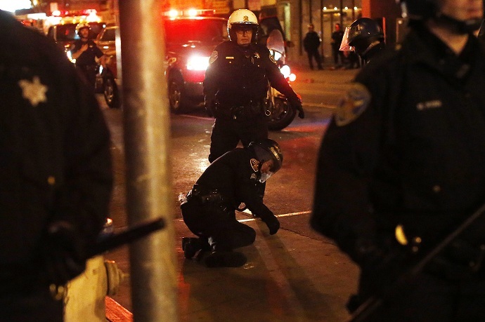 An injured police officer is seen on the ground after being hit by a glass bottle as revellers celebrate in the Mission District, in San Francisco (Reuters/Stephen Lam)