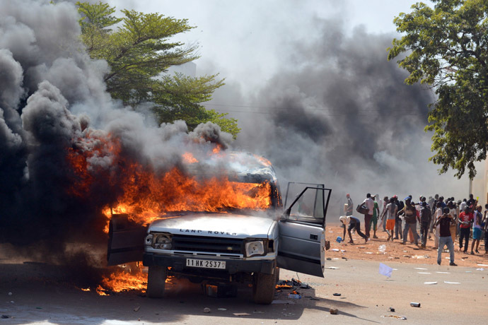 Cars and documents burn outside the parliament in Ouagadougou on October 30, 2014. (AFP Photo/Issouf Sango)