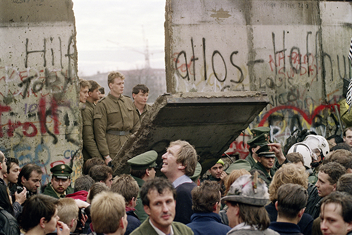 November 11, 1989. West Berliners crowd in front of the wall watching East German border guards demolish a section to open a new crossing point between East and West Berlin, near the Potsdamer Platz. (AFP Photo / Gerard Malie) 