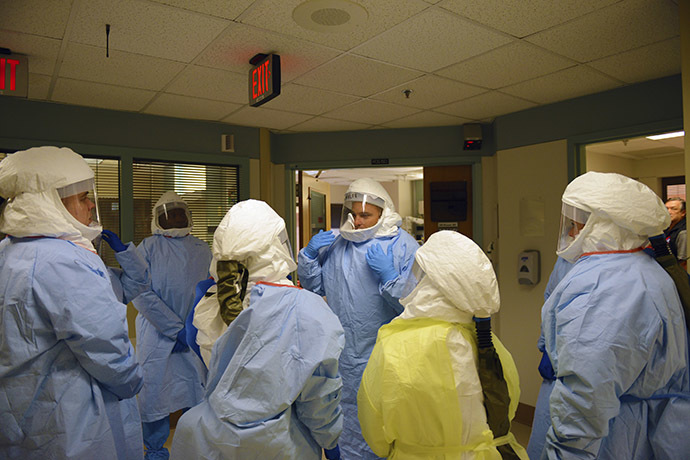 Navy Cmdr. (Dr.) James Lawler (C), an infectious disease physician, talks to team members during a training event at the San Antonio Military Medical Center on Joint Base San Antonio-Fort Sam Houston, Texas, in this handout picture taken October 25, 2014. (Reuters/Department of Defense)