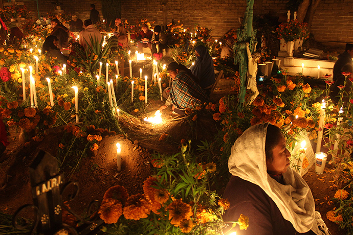 Women sit next to the graves of their relatives on the Day of the Dead, at a cemetery in Santa Maria Atzompa, on the outskirts of Oaxaca (Reuters / Jorge Luis Plata)