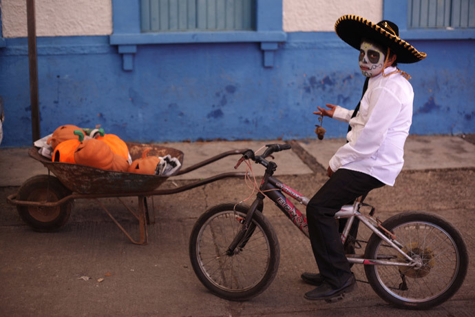 A boy with his face painted as a skull poses for a photo during the start of the "Las Catrinas" festival, ahead of the Day of the Dead in Cupula on the outskirts of Morelia, Mexico (Reuters / Alan Ortega)