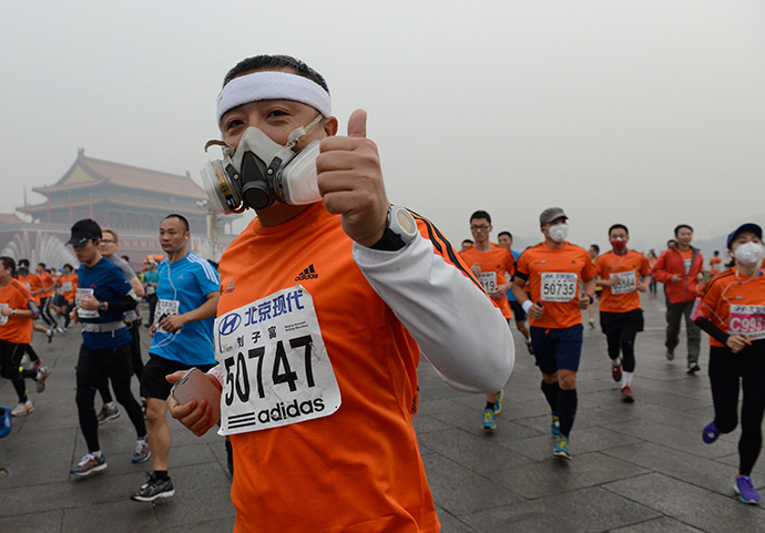 Participants wearing masks during a hazy day at the Beijing International Marathon in front of Tiananmen Square, in Beijing, October 19, 2014 (Reuters / Stringer)