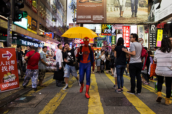 A pro-democracy supporter dressed as comic book character Spider-Man carries a yellow umbrella, regarded a symbol of the Occupy civil disobedience movement, on a road blocked by protesters at Mongkok shopping district in Hong Kong October 24,2014 (Reuters / Tyrone Siu)