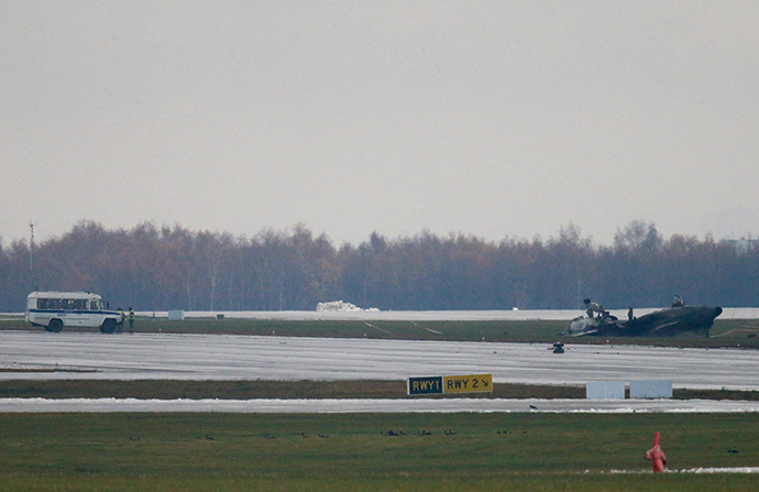 A police vehicle (L) stands near the wreckage of what is believed to be Christophe de Margerie's Dassault Falcon jet at Moscow's Vnukovo airport, October 21, 2014 (Reuters / Maxim Zmeyev)