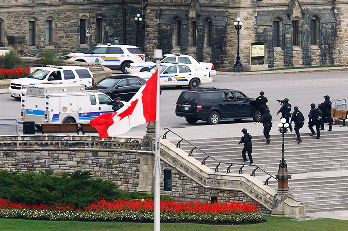 Armed RCMP officers approach Centre Block on Parliament Hilll following a shooting incident in Ottawa October 22, 2014 (Reuters / Chris Wattie)