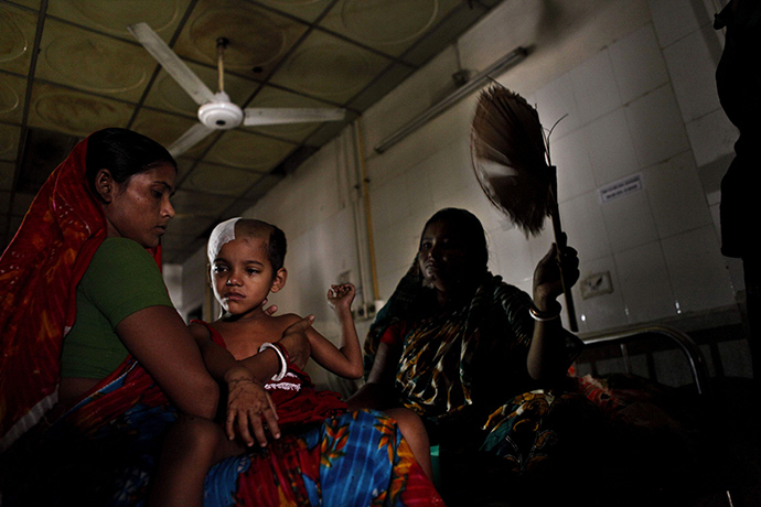 A Bangladesh woman fans a sick child during a power blackout at a hospital in Dhaka on November 1, 2014 (AFP Photo)