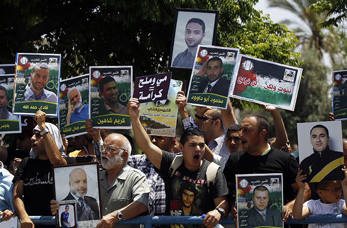 Relatives and friends of Palestinians jailed in Israeli prisons hold placards as they take part in a protest calling for the prisoners release outside Ayalon prison, in the city of Ramle, near Tel Aviv May 23, 2014. (Reuters/Ammar Awad)