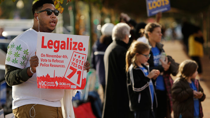 Melvin Clay (L) of the DC Cannabis Campaign holds a sign urging voters to legalize marijuana, at the Eastern Market polling station in Washington November 4, 2014.(Reuters / Gary Cameron)