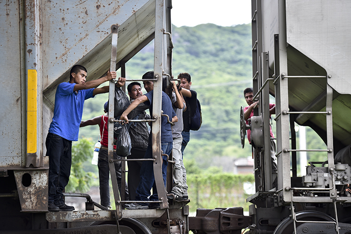 Central American migrants ride the train called "The Beast" in their attemp to reach the border between Mexico and the United States (AFP Photo / Yuri Cortez)
