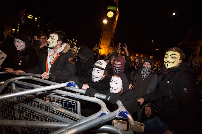 Anti-capitalist protesters wearing Guy Fawkes masks remove police barrickades during the "Million Masks March" in Parliament Square in London on November 5, 2014. (AFP Photo / Jack Taylor)