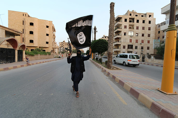 A member loyal to the Islamic State in Iraq and the Levant (ISIL) waves an ISIL flag in Raqqa June 29, 2014. (Reuters / Stringer)