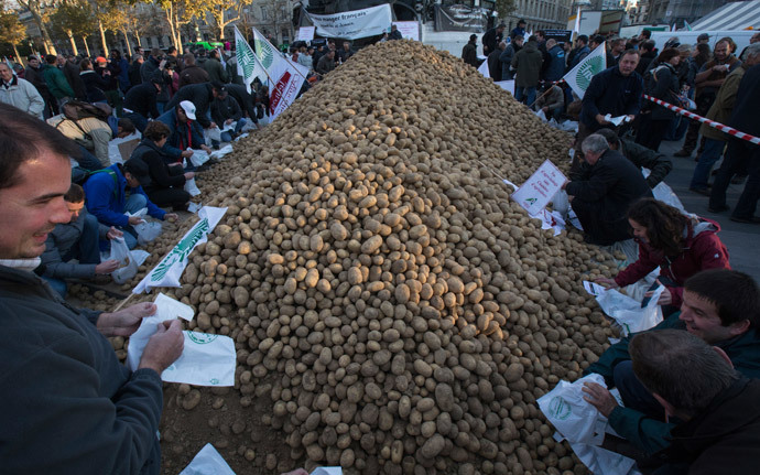 Farmers puts potatoes in bags before a distribution at Republique square in central Paris, November 5, 2014.(Reuters / Philippe Wojazer)