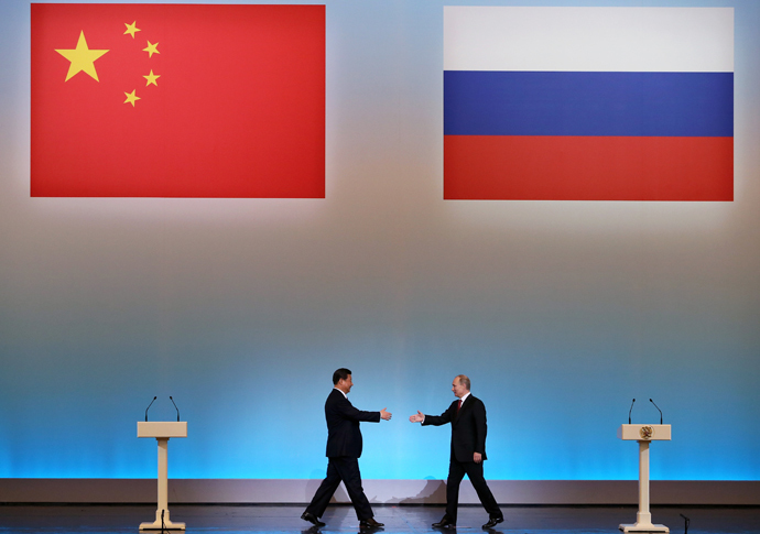 China's President Xi Jinping (L) is welcomed by his Russian counterpart Vladimir Putin (R) during the opening ceremony of "The Year of Chinese Tourism in Russia" in Moscow, on March 22, 2013. (AFP Photo / Pool / Sergei Ilnitsky)