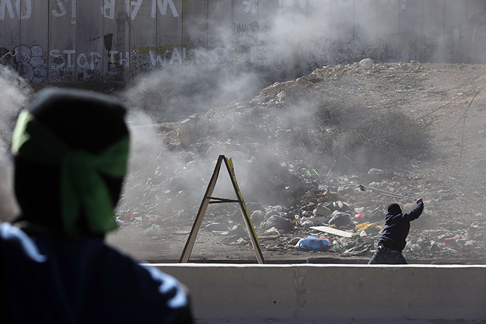 A Palestinian protester hurls a stone with a sling towards Israeli troops during clashes following a protest against what organizers say are recent visits by Jewish activists to al-Aqsa mosque, at Qalandia checkpoint near the West Bank city of Ramallah November 7, 2014. (Reuters/Ammar Awad)