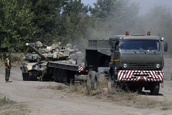 A Russian soldier stands next to a tank ready to be loaded on a truck in Kamensk-Shakhtinsky, Rostov region, near the border with Ukraine. (Reuters/Alexander Demianchuk)