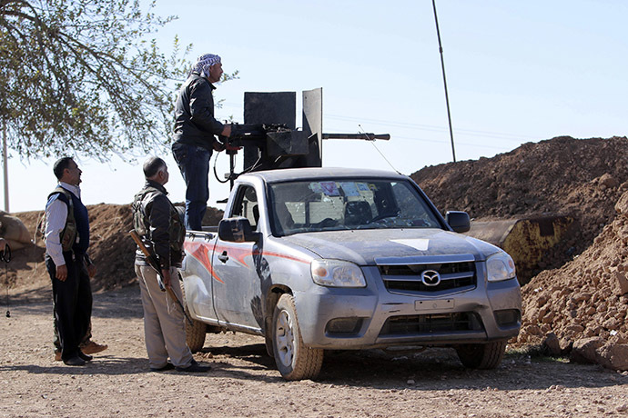 A member of the Kurdish People's Protection Units (YPG) aims a weapon mounted on a pick-up truck towards areas controlled by Islamic State fighters in the southern countryside of Ras al-Ain November 7, 2014. (Reuters/Rodi Said)