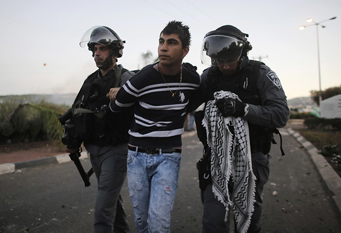 Israeli policemen detain an Arab youth during clashes at the entrance to the town of Kfar Kanna, north of Israel, November 8, 2014. (Reuters/Ammar Awad)
