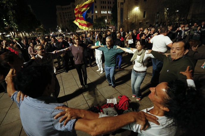 People take part in a Sardana dance, a typical Catalan dance, near the cathedral in Barcelona, November 8, 2014. (Reuters/Gustau Nacarino)