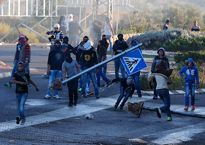 Israeli Arab youths clash with Israeli police at the entrance to the town of Kfar Kanna, in northern Israel, November 8, 2014 (Reuters / Ammar Awad)