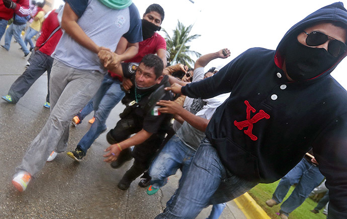 Demonstrators hold a riot police during clashes following a protest against the suspected massacre of 43 missing students, near the airport in Acapulco, in the Mexican state of Guerrero State, on November 10, 2014. (AFP Photo/Pedro Pardo)