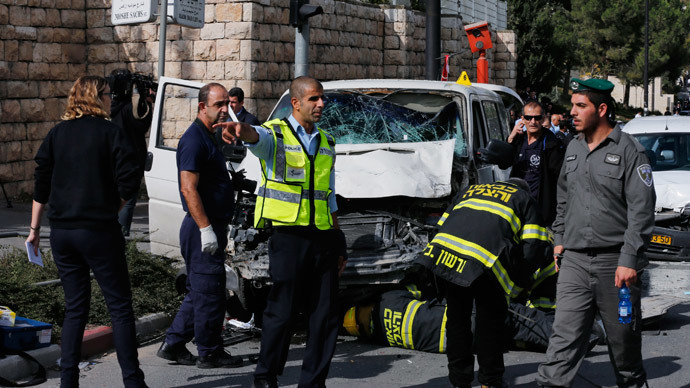 An Israeli police officer gestures in front of the vehicle of a Palestinian motorist who rammed into pedestrians at the scene of the attack in Jerusalem November 5, 2014.(Reuters / Ammar Awad )