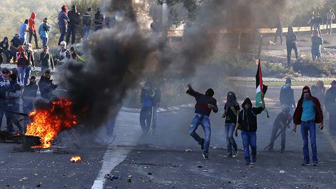 Israeli Arab youths throw stones during clashes with Israeli police at the entrance to the town of Kfar Kanna, in the North of Israel, November 8, 2014. (Reuters/Ammar Awad)