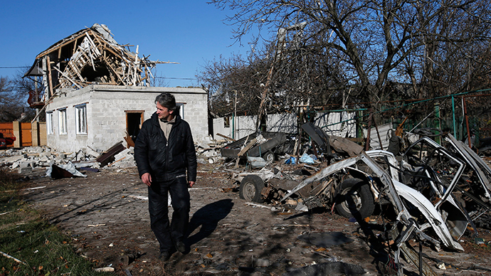 A man walks past a residential block and a car damaged by recent shelling in Donetsk, eastern Ukraine (Reuters / Maxim Zmeyev)